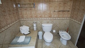 Ein Badezimmer mit Badewanne, Toilette, Bidet und Handtuchhalter.
