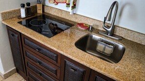 Eine Küche mit Granit Arbeitsplatten, einer Edelstahl-Spüle und einem eingebauten Ofen.