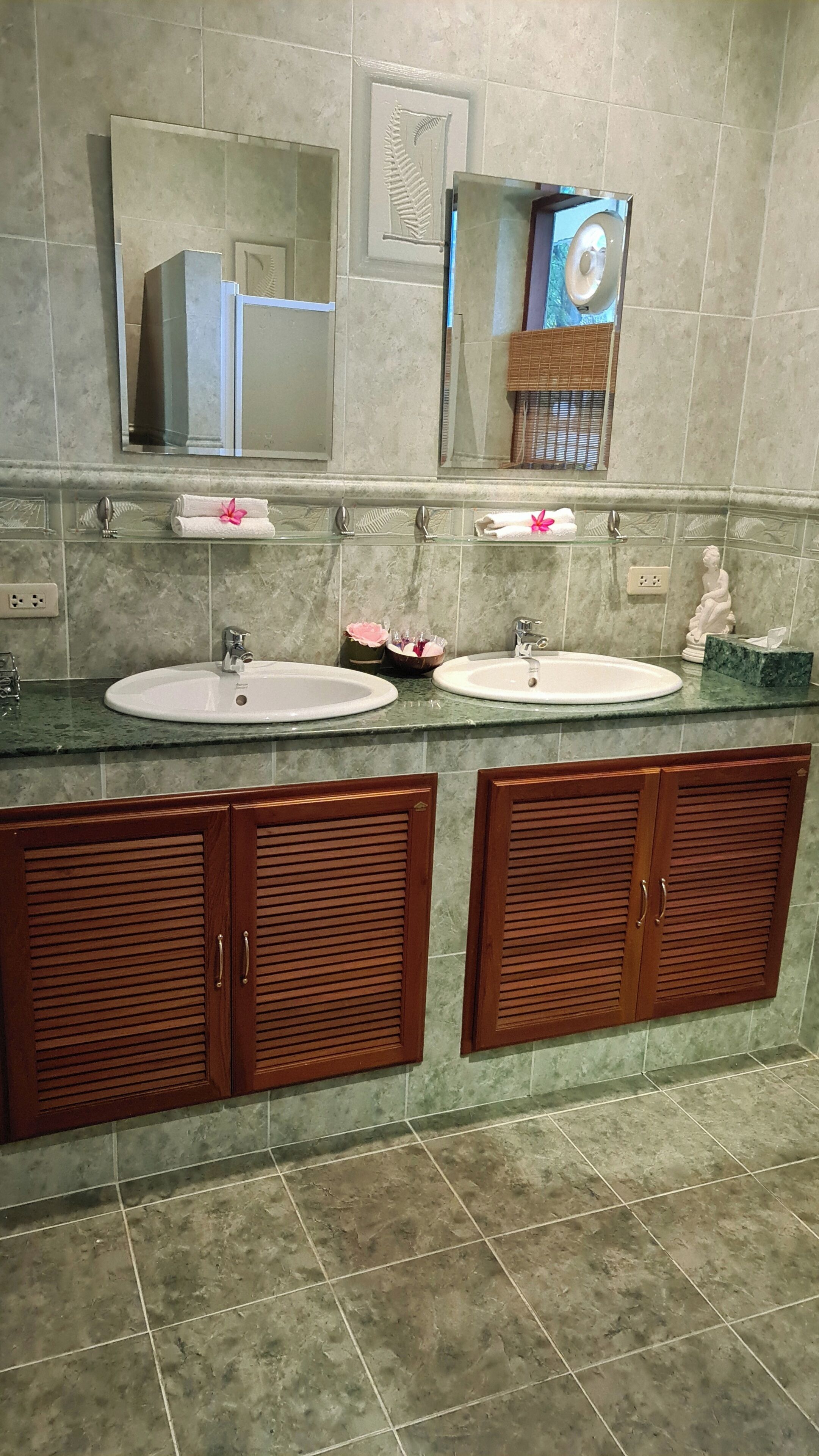 A bathroom with two sinks, a mirror, and wooden cabinets.