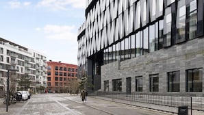 A modern building with large windows and a paved walkway. - Charm 1 - Chic 2-bdr Apt With Shared Garden (Copenhagen)