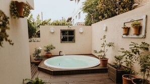 A wooden deck with a hot tub surrounded by potted plants. - Paty's Garden (Florianópolis)