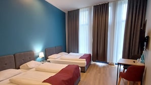 A hotel room with two beds, a desk, a chair, a TV, and a window with curtains. - Trip Inn Düsseldorf Neuss (Neuss)