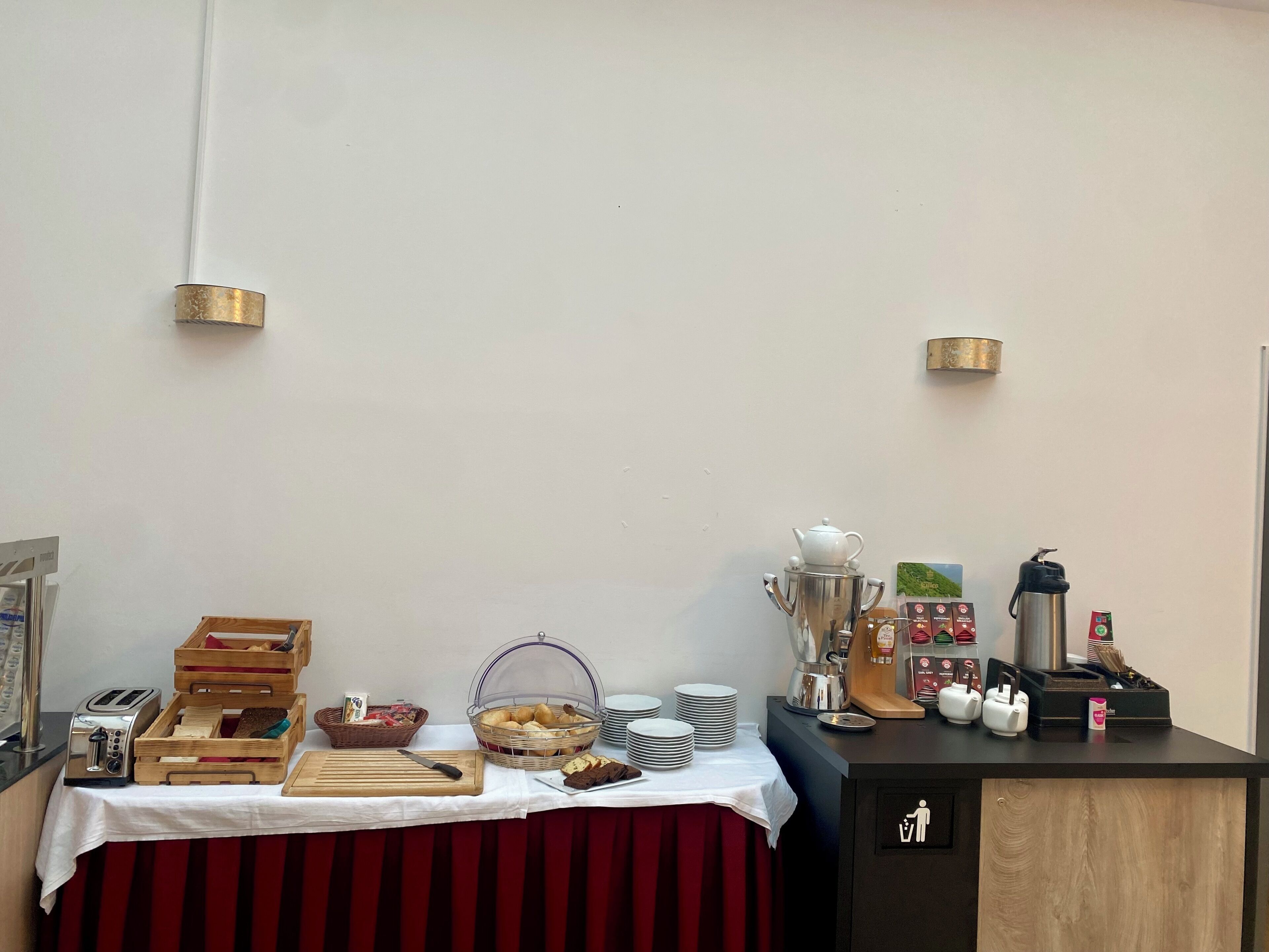 A breakfast buffet setup with bread, pastries, and a coffee station.