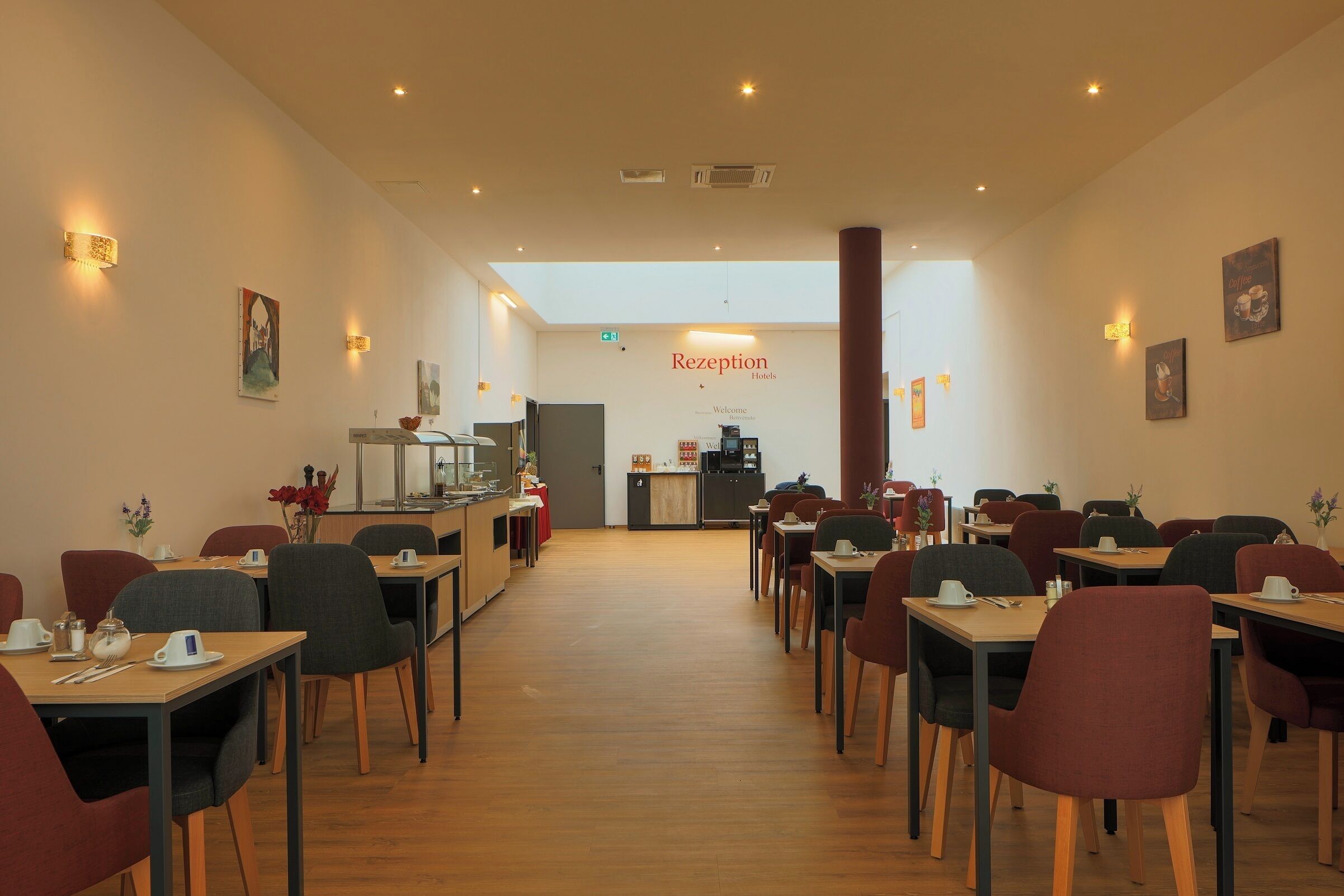 Un espace d’accueil avec une pancarte indiquant « Réception, les hôtels vous souhaitent la bienvenue ». Des tables et des chaises sont disposées pour les clients.
