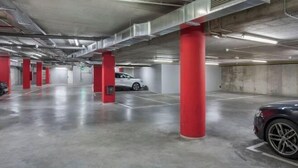 A multi-level parking garage with red pillars and white walls.