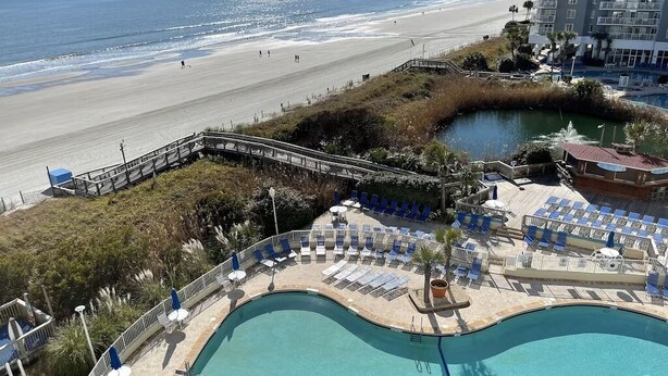 A resort with a swimming pool, beach access, and a view of the ocean. - Sea Watch Resort (Myrtle Beach)