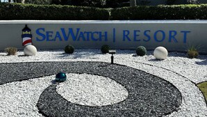 A sign for SeaWatch Resort with a circular gravel design and decorative elements. - Sea Watch Resort (Myrtle Beach)