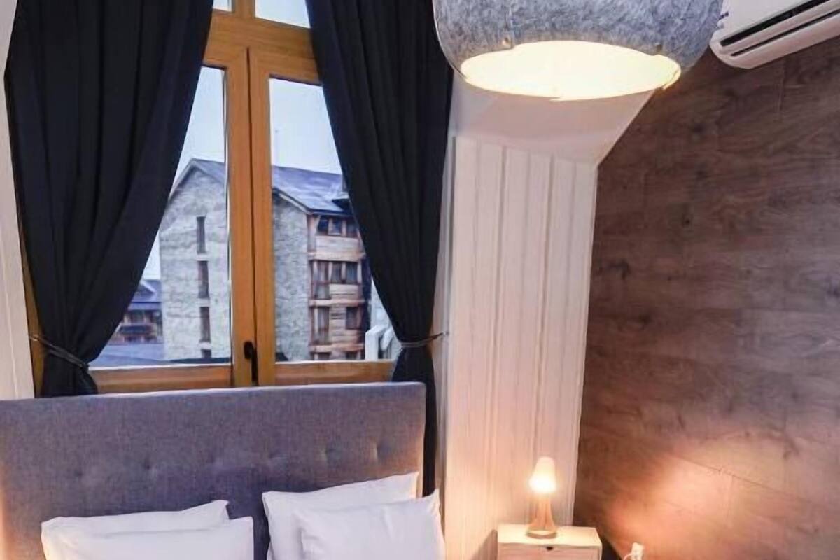 Relax in comfort with a large bed, wooden headboard, and a cozy reading nook.
