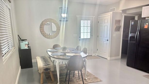 A dining area with a round table, chairs, and a bench. There is a mirror on the wall, a door, and a refrigerator in the background. - Desert Ranch Home + 3 Horse stalls. Views of the Rincon Mountains (Tucson)