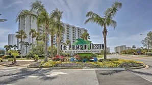 The Palms of Destin Resort & Conference Center mit auffälliger Beschilderung, Palmen und blauem Himmel.
