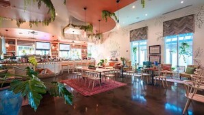 Ein geräumiges Café mit modernem Interieur, das eine Bar, Sitzgelegenheiten und große Fenster mit viel Tageslicht bietet.