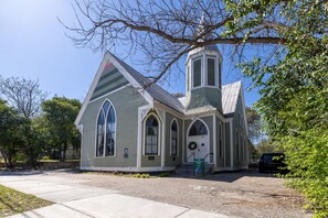 Una pequeña iglesia con campanario y ventanas de arco.