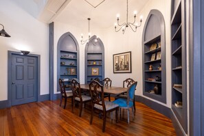 Un comedor con una mesa de madera, sillas y estanterías empotradas.