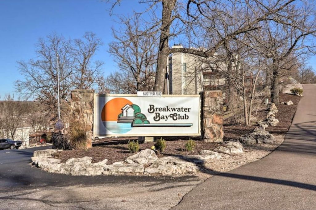 A sign for Breakwater Bay Club with a clear view of the surrounding landscape.