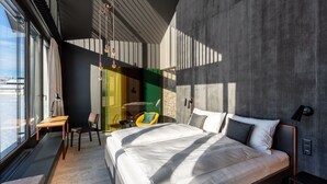 Un dormitorio moderno con una cama grande, un escritorio y una silla.