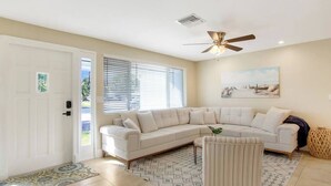 A living room with a large L-shaped sectional sofa, a single armchair, and a patterned rug. - 3 Bed, 2 Bath - North Palm Beach! (North Palm Beach)