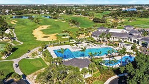A golf course with a swimming pool area, including lounge chairs and palm trees. - 3 Bed, 2 Bath - North Palm Beach! (North Palm Beach)