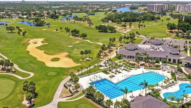 A golf course with a swimming pool and a resort building. - 3 Bed, 2 Bath - North Palm Beach! (North Palm Beach)