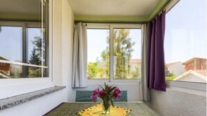 Ein Balkon mit Tisch, Stühlen und einem Blumenstrauß.