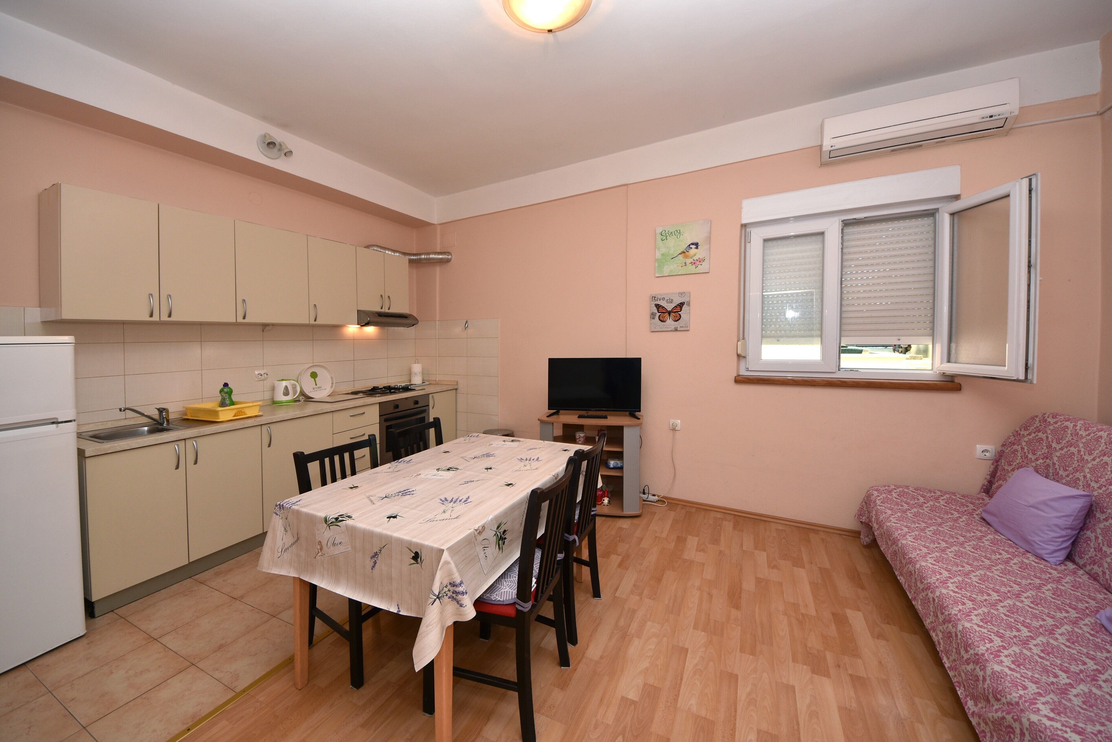 A compact living space with a kitchen, dining area, and a sofa.