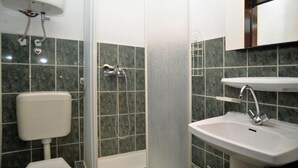 Un baño con inodoro, ducha y lavabo.