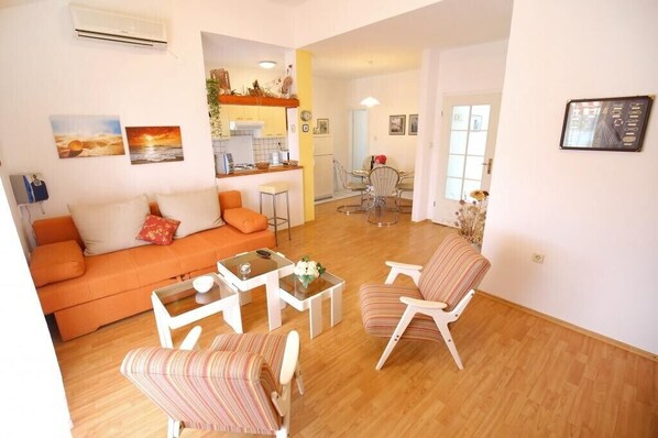 A living room with a sofa, chairs, a coffee table, and a dining area with a table and chairs.