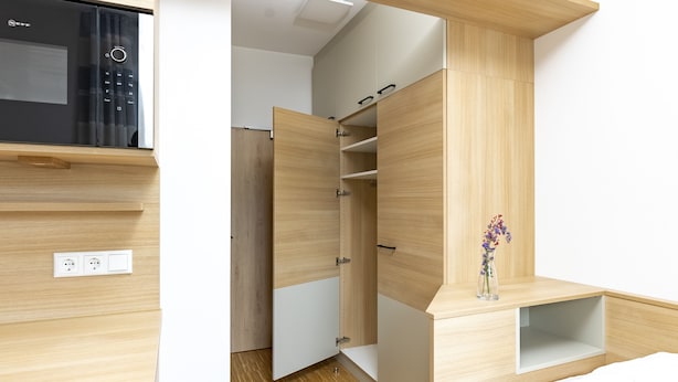 Un dormitorio moderno con armario empotrado, mesita de noche y microondas.