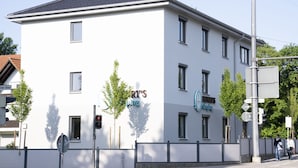 Un edificio con un letrero que dice 'RY'S Sleeping' y 'Henry's Sleeping'. Hay tres árboles delante del edificio.