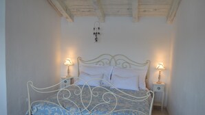 A bedroom with a bed, two bedside tables, and a wall-mounted dreamcatcher.