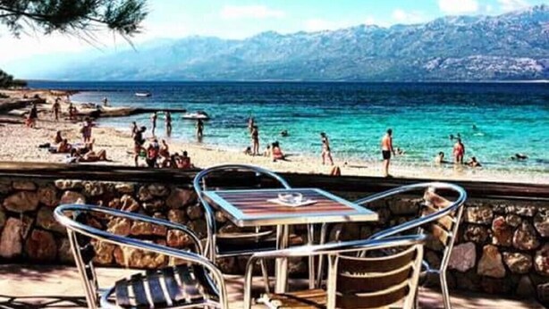 A beachside patio with stone walls, metal chairs, and a table. - Apartments Branka - One Bedroom Apartment with Balcony (Razanac)