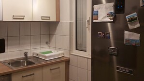 A modern kitchen with a stainless steel refrigerator, a sink, and light-colored cabinets. - Apartments Branka - Two Bedroom Apartment with Terrace (Razanac)