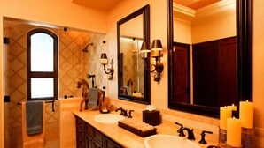 A bathroom with two sinks, a large mirror, wall sconces, and candles. - ULTIMATE LUXURY OCEANVIEW CABO HOME W/PRIVATE POOL & GOLF. NOVAISPANIA (Cabo San Lucas)
