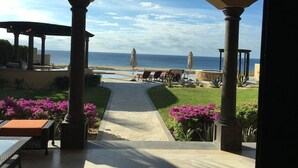 A covered outdoor area with a view of the ocean, featuring a pathway, seating, and decorative plants. - ULTIMATE LUXURY OCEANVIEW CABO HOME W/PRIVATE POOL & GOLF. NOVAISPANIA (Cabo San Lucas)