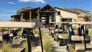 A golf cart parking area with a building in the background. - ULTIMATE LUXURY OCEANVIEW CABO HOME W/PRIVATE POOL & GOLF. NOVAISPANIA (Cabo San Lucas)