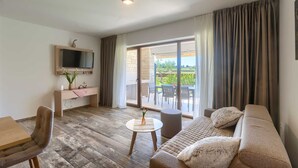 A living room with a sofa, a TV, a dining table, and a view of the outdoors. - Brand New Modern apartment for 6+2 guests with shared pool (Novigrad)