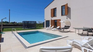 A modern house with a swimming pool, outdoor seating, and a covered play area. - Brand New Modern apartment for 6+2 guests with shared pool (Novigrad)