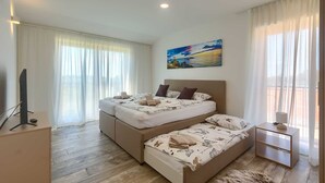 A bedroom with a double bed, a side table, a painting, and a television. - Brand New Modern apartment for 6+2 guests with shared pool (Novigrad)