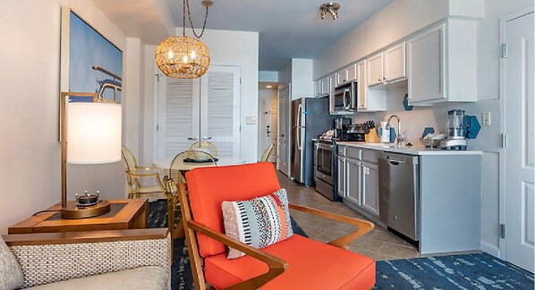 Relax in a stylish room with a seating area, kitchenette, and large mirror.
