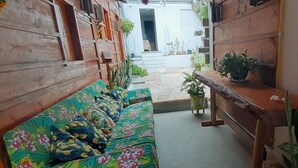 A cozy seating area with a floral sofa and a wooden bench. - Pousada Estresse Zero (Barreirinhas)