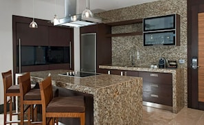 A modern kitchen with granite countertops, stainless steel appliances, and a built-in TV.