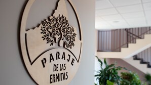 A circular wooden sign with a tree design and the text "PARAJE DE LAS ERMITAS". - Las Ermitas de Vallada (Vallada)