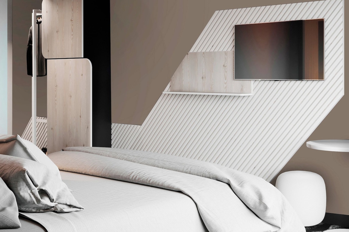 Un dormitorio moderno con cama, mesita de noche, televisor y un diseño de pared original.