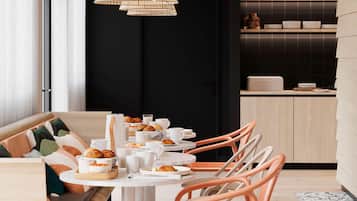 A modern dining area with a round table, orange chairs, and a black wall in the background.