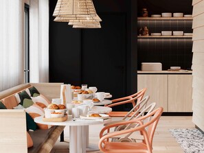A modern dining area with a round table, orange chairs, and a black wall in the background. - Ibis Styles Porto Vecchio (Porto-Vecchio)