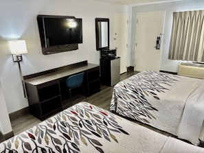 A hotel room with a TV, desk, chair, two beds, and a microwave. - Red Roof Inn Birmingham (Birmingham)