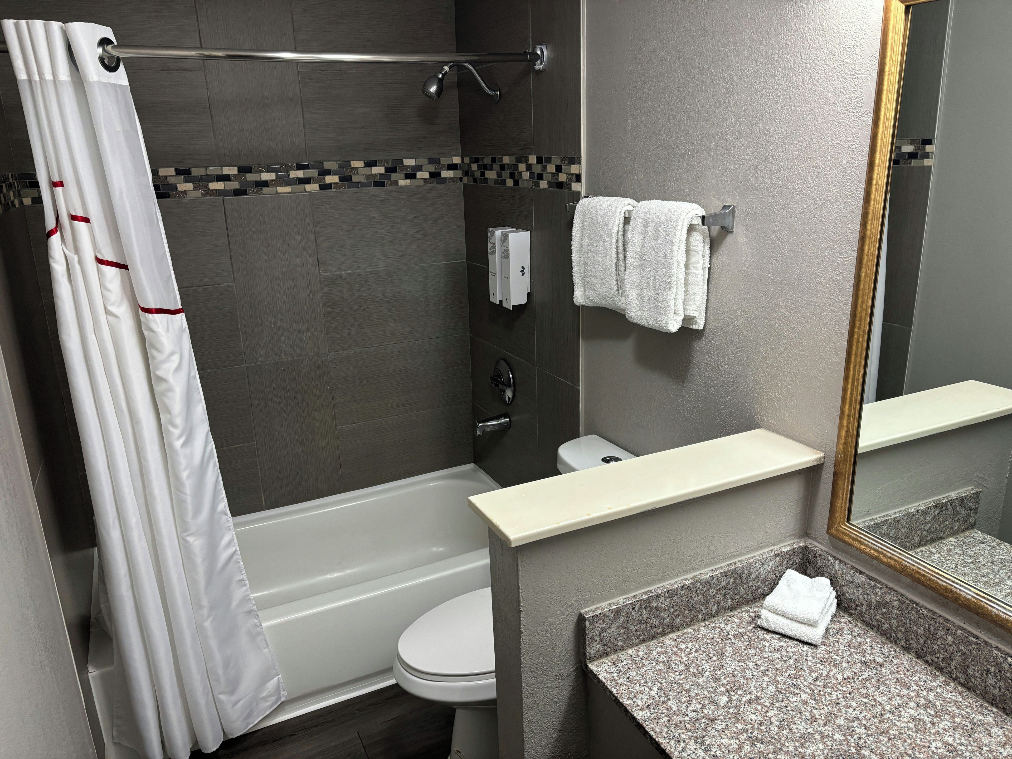 A modern bathroom with a bathtub, toilet, and sink.
