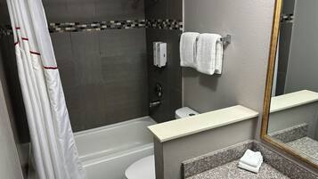 A modern bathroom with a bathtub, toilet, and sink.