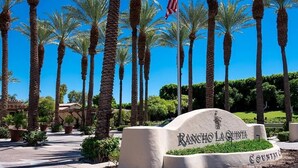 A sign with "Rancho La Quinta" and "Country Club" text, surrounded by palm trees and a clear blue sky. - Rancho La Quinta community with amazing pool (La Quinta)