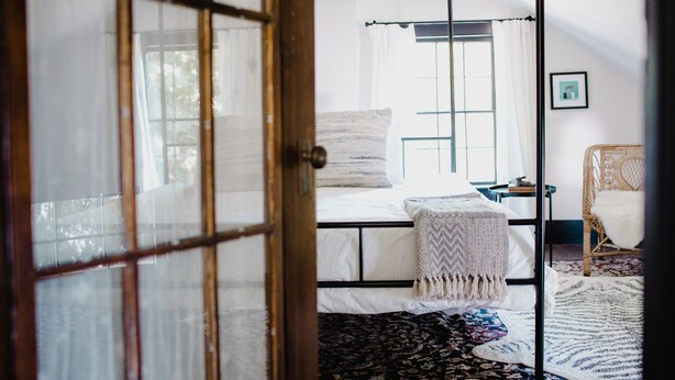 A room with a bed, a chair, a window, and a door. - The Starling at Pond Eddy, Cottage (Pond Eddy)