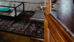 A living room with a white sofa, a coffee table, and a patterned rug. - The Starling at Pond Eddy, Cottage (Pond Eddy)